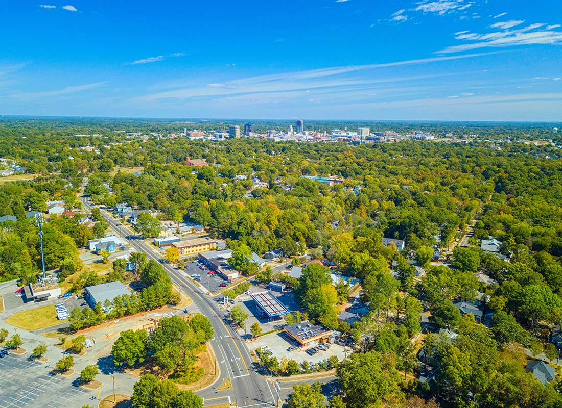 Goldsboro, NC - Aerial View of Businesses and Homes Surrounded by Green Trees in the City of Goldsboro North Carolina on a Sunny Summer Day