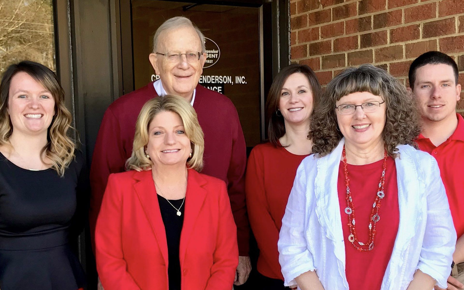 Homepage - The Crawford-Henderson Insurance Team Posing Together in Front of the Entrance to Their Office